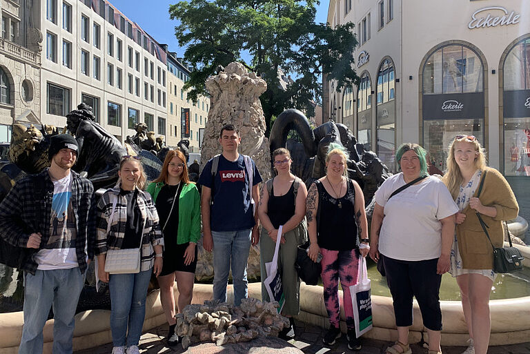 Schüler stehen vor dem Brunnen "Ehekarussell" in Nürnberg
