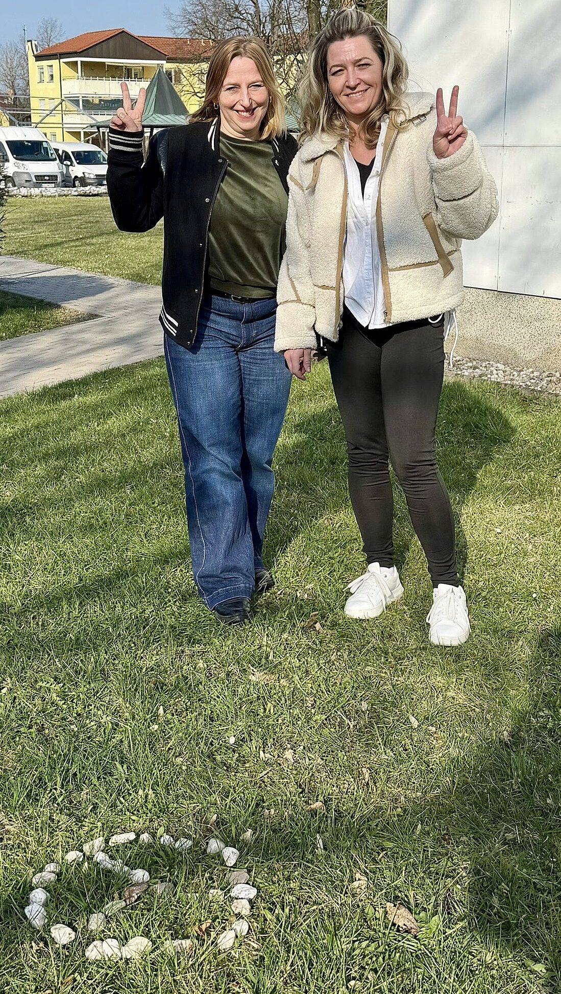 Zwei Schülerinnen stehen auf einer Wiese