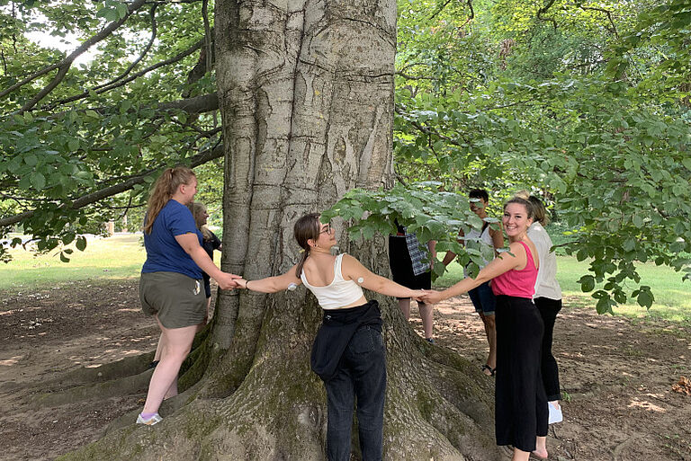 Schüler*innen des Hep1 tanzen um einen Baum