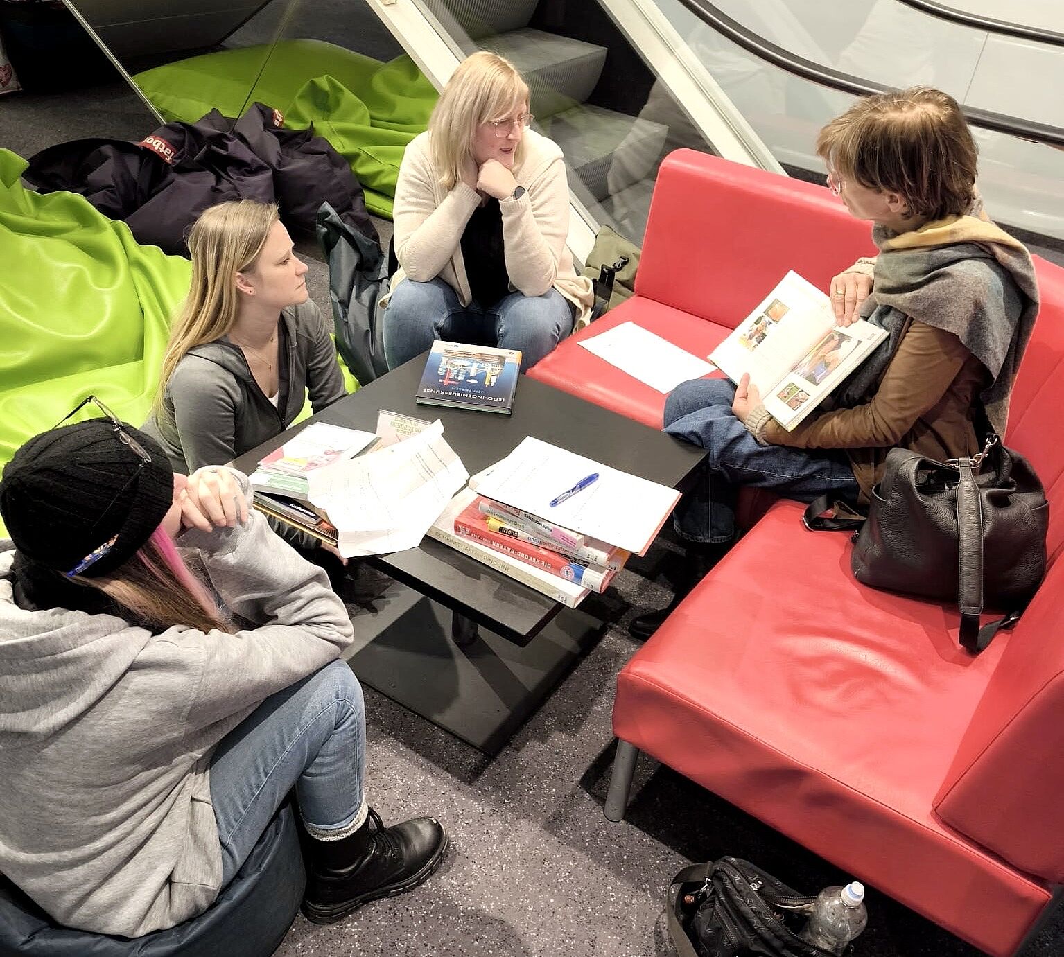 Schülerinnen sitzen zusammen und besprechen Bücher